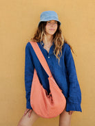 Nina Bag a righe arancioni indossata a tracolla